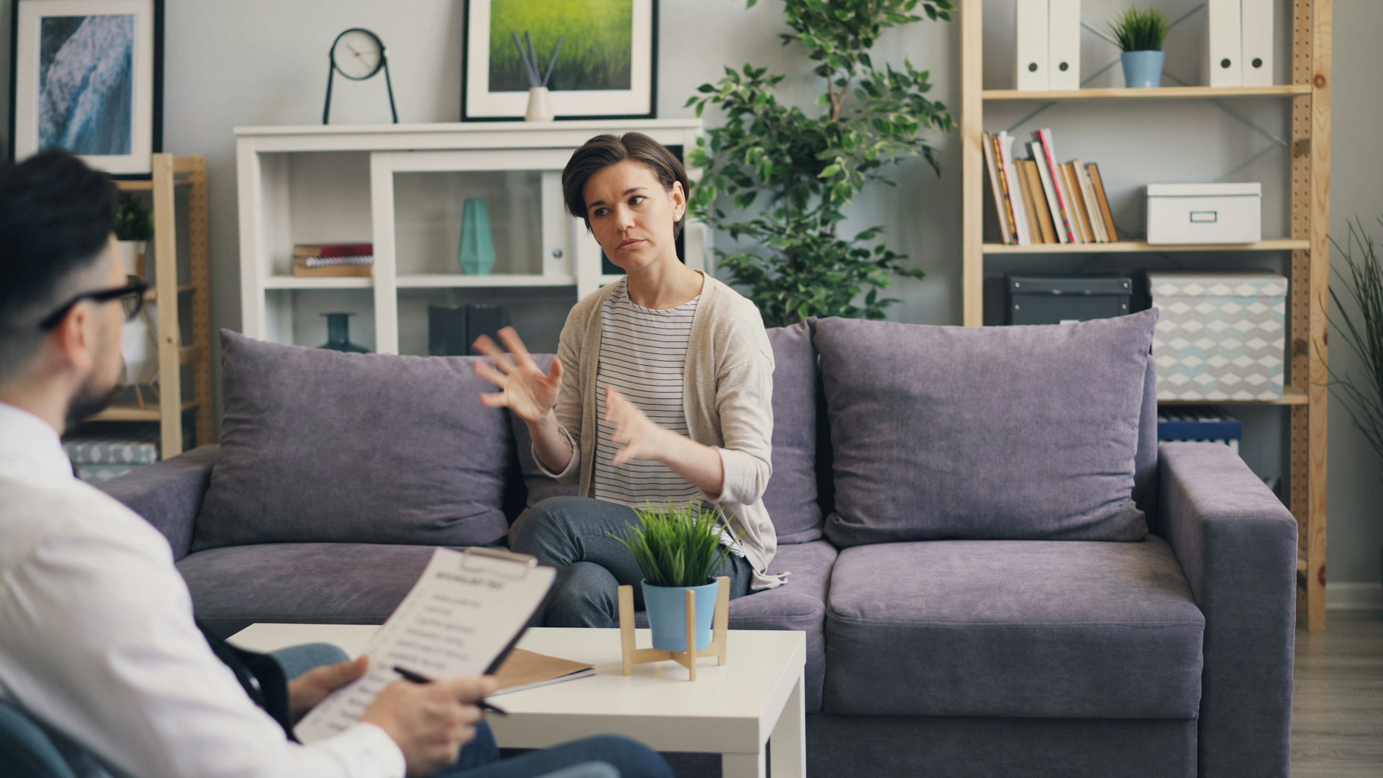 a-woman-sitting-on-a-couch-talking-to-a-man.jpg a woman sitting on a couch talking to a man
